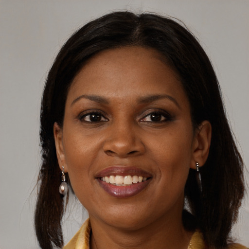 Joyful black young-adult female with long  brown hair and brown eyes