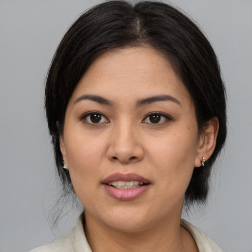 Joyful latino young-adult female with medium  brown hair and brown eyes