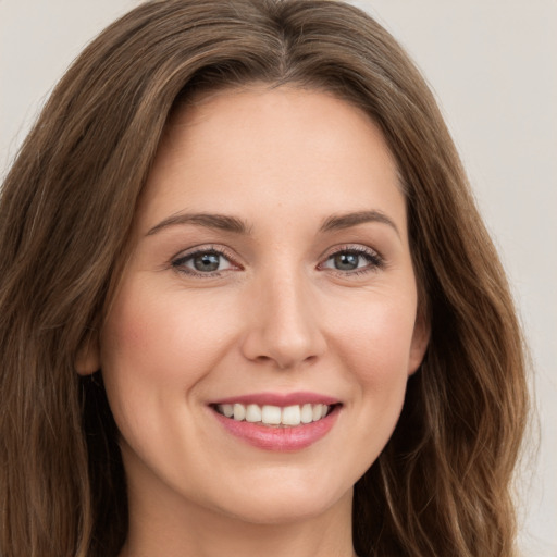 Joyful white young-adult female with long  brown hair and green eyes