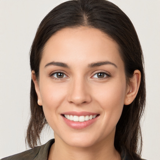 Joyful white young-adult female with long  brown hair and brown eyes