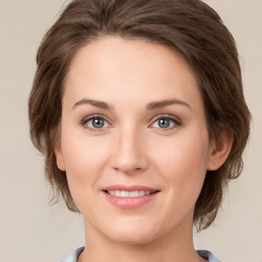 Joyful white young-adult female with medium  brown hair and green eyes