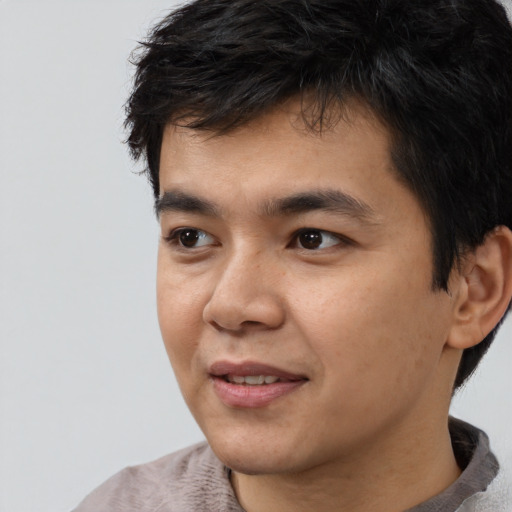 Joyful asian young-adult male with short  black hair and brown eyes