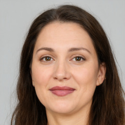 Joyful white adult female with long  brown hair and brown eyes