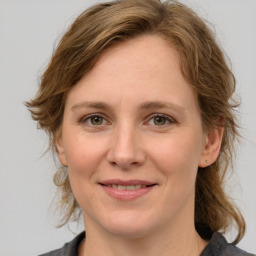 Joyful white young-adult female with medium  brown hair and green eyes