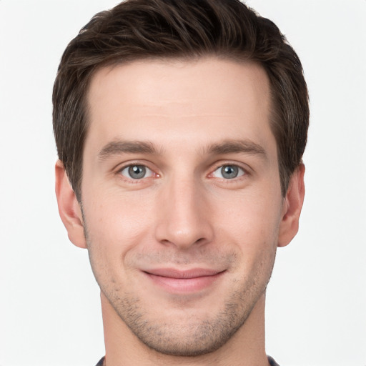 Joyful white young-adult male with short  brown hair and grey eyes