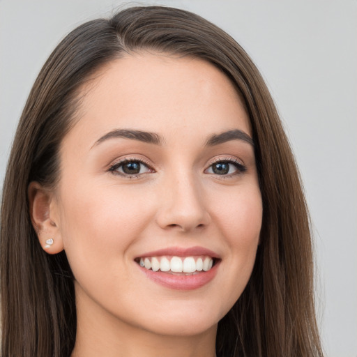 Joyful white young-adult female with long  brown hair and brown eyes