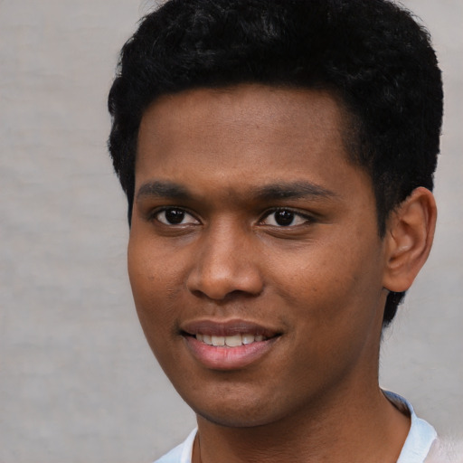 Joyful black young-adult male with short  black hair and brown eyes