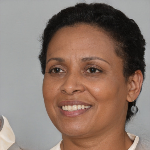 Joyful black adult female with short  brown hair and brown eyes