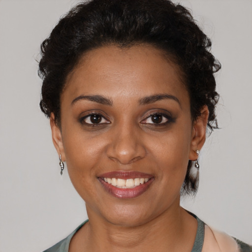 Joyful black young-adult female with short  brown hair and brown eyes