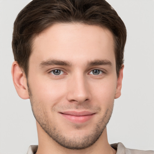 Joyful white young-adult male with short  brown hair and grey eyes