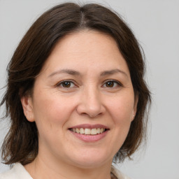 Joyful white adult female with medium  brown hair and brown eyes