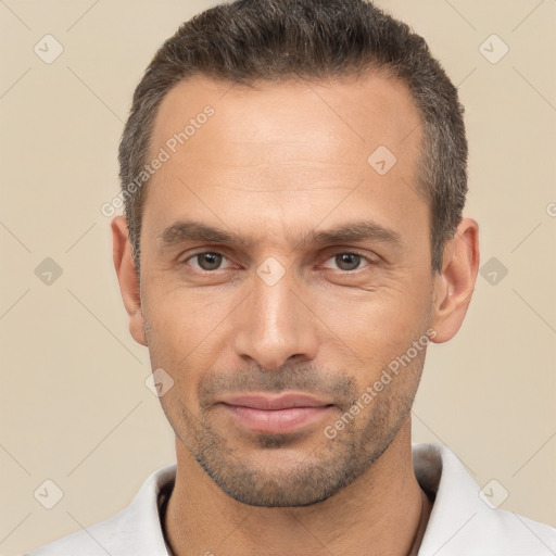 Joyful white adult male with short  black hair and brown eyes