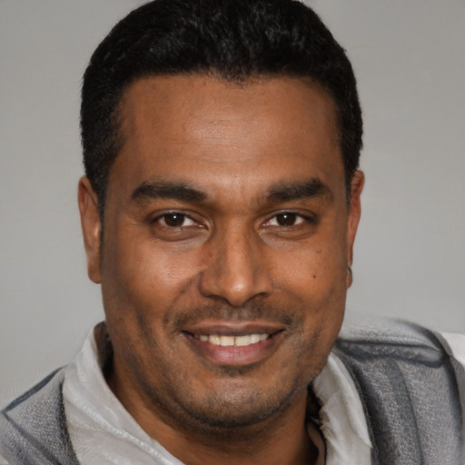 Joyful latino young-adult male with short  black hair and brown eyes