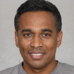 Joyful latino adult male with short  black hair and brown eyes
