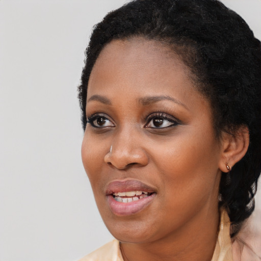 Joyful black young-adult female with long  black hair and brown eyes