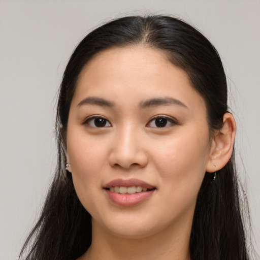 Joyful asian young-adult female with long  brown hair and brown eyes