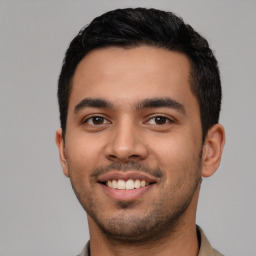 Joyful latino young-adult male with short  black hair and brown eyes