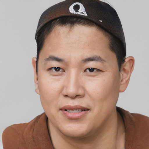 Joyful asian adult male with short  brown hair and brown eyes