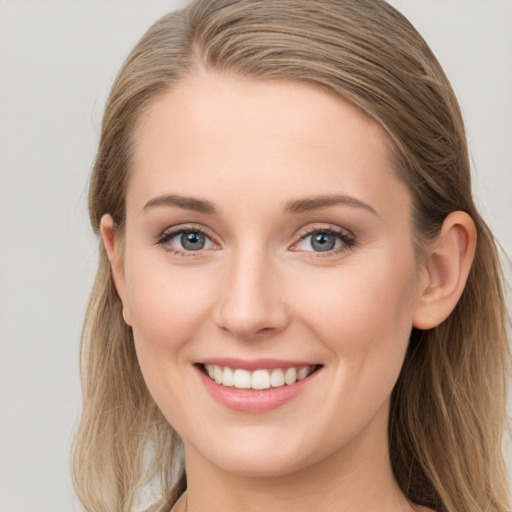 Joyful white young-adult female with long  brown hair and blue eyes