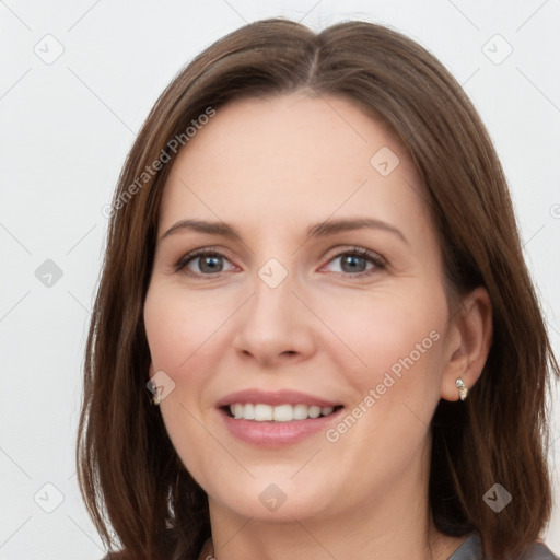 Joyful white young-adult female with long  brown hair and grey eyes