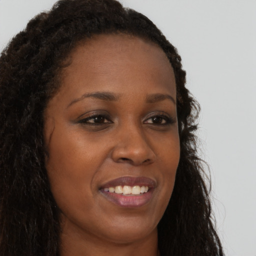 Joyful black young-adult female with long  brown hair and brown eyes