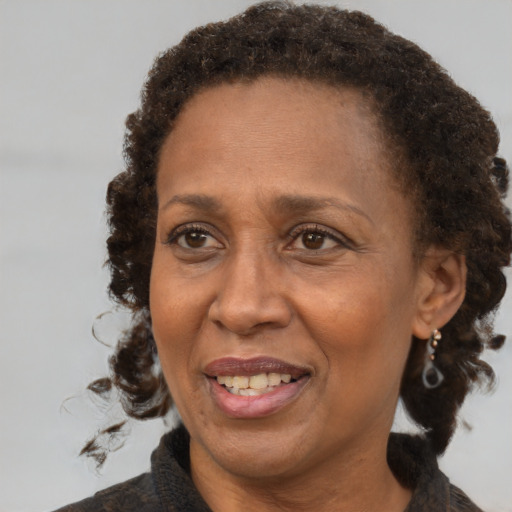 Joyful black adult female with medium  brown hair and brown eyes