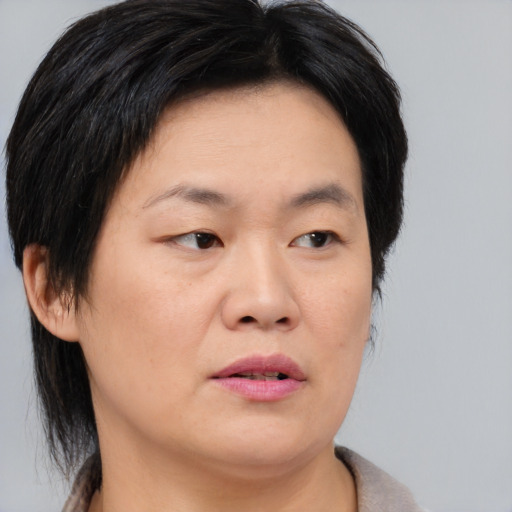 Joyful asian adult female with medium  brown hair and brown eyes