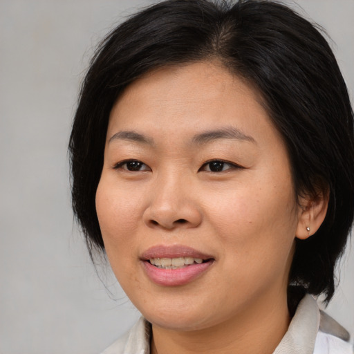 Joyful asian young-adult female with medium  brown hair and brown eyes