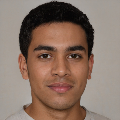 Joyful latino young-adult male with short  brown hair and brown eyes