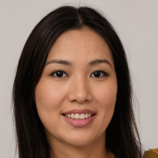 Joyful asian young-adult female with long  brown hair and brown eyes