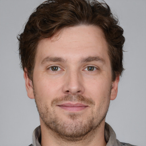 Joyful white adult male with short  brown hair and grey eyes