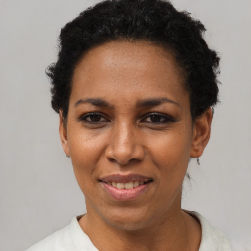 Joyful black adult female with short  black hair and brown eyes