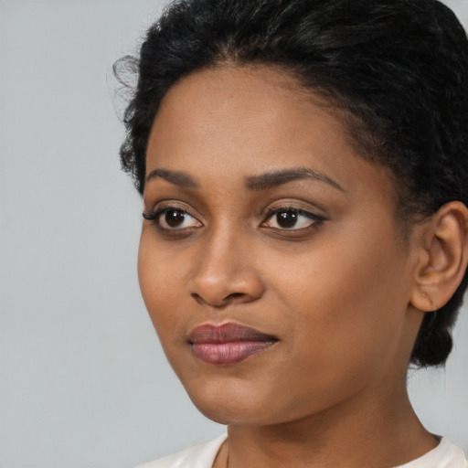 Joyful black young-adult female with short  black hair and brown eyes