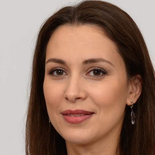 Joyful white adult female with long  brown hair and brown eyes