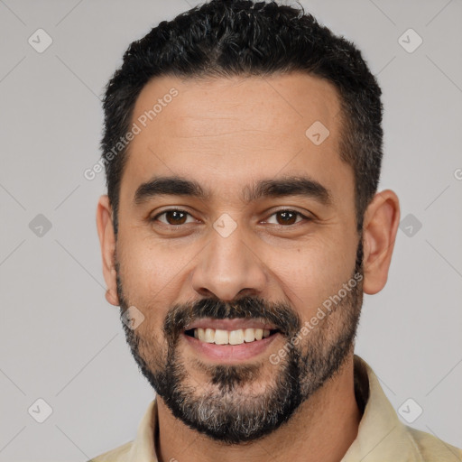 Joyful latino young-adult male with short  black hair and brown eyes