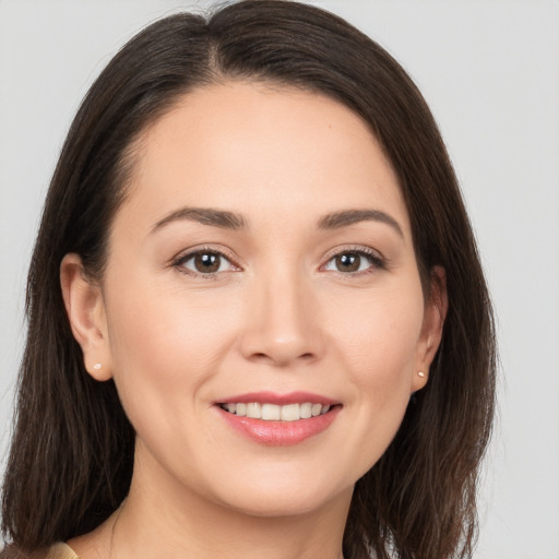 Joyful white young-adult female with long  brown hair and brown eyes