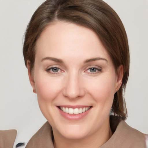 Joyful white young-adult female with medium  brown hair and grey eyes