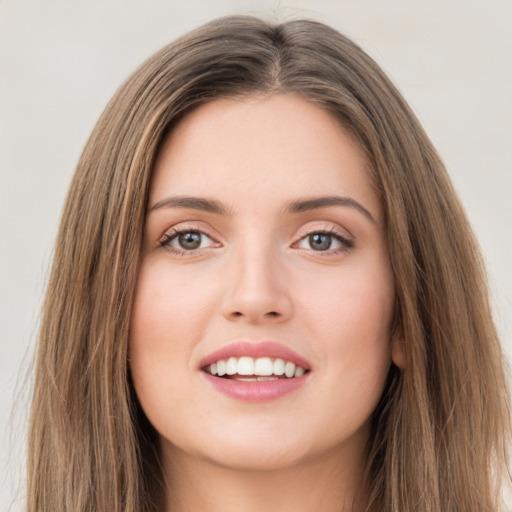 Joyful white young-adult female with long  brown hair and green eyes