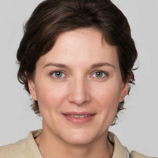 Joyful white young-adult female with medium  brown hair and grey eyes