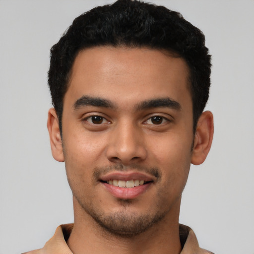 Joyful latino young-adult male with short  black hair and brown eyes