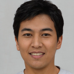 Joyful asian young-adult male with short  black hair and brown eyes