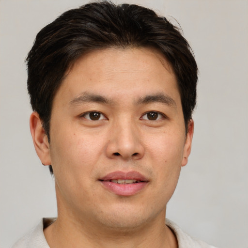 Joyful asian young-adult male with short  brown hair and brown eyes