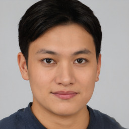 Joyful asian young-adult male with short  brown hair and brown eyes