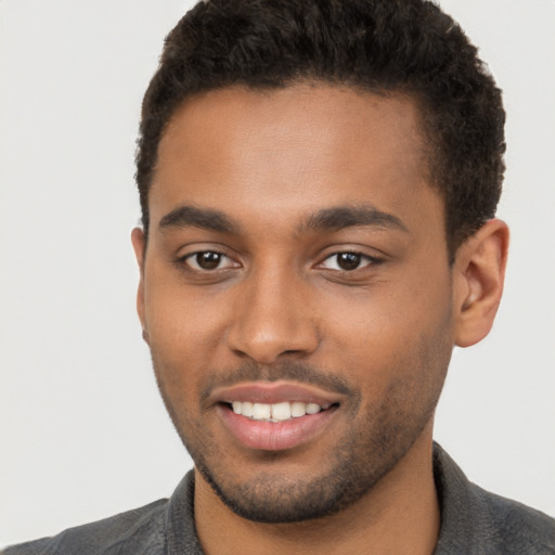 Joyful black young-adult male with short  brown hair and brown eyes