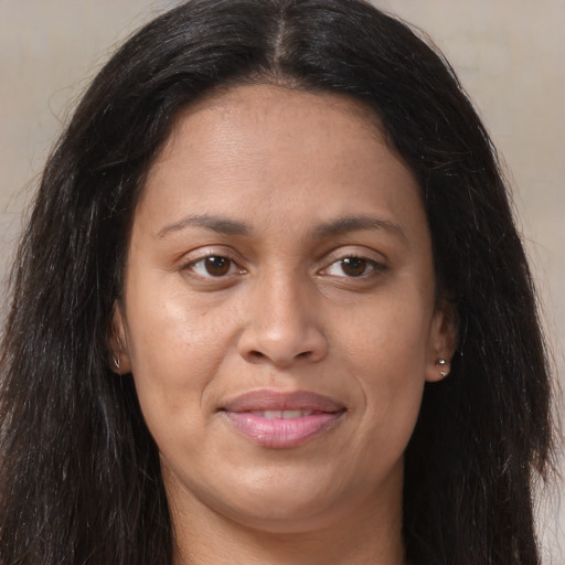 Joyful latino adult female with long  brown hair and brown eyes