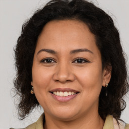 Joyful latino adult female with medium  brown hair and brown eyes