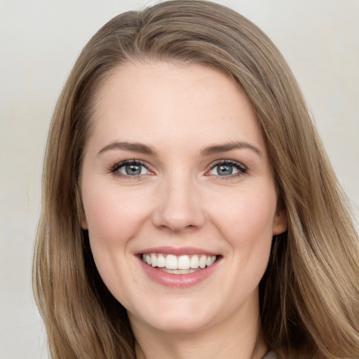 Joyful white young-adult female with long  brown hair and grey eyes