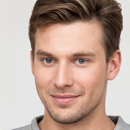 Joyful white young-adult male with short  brown hair and grey eyes