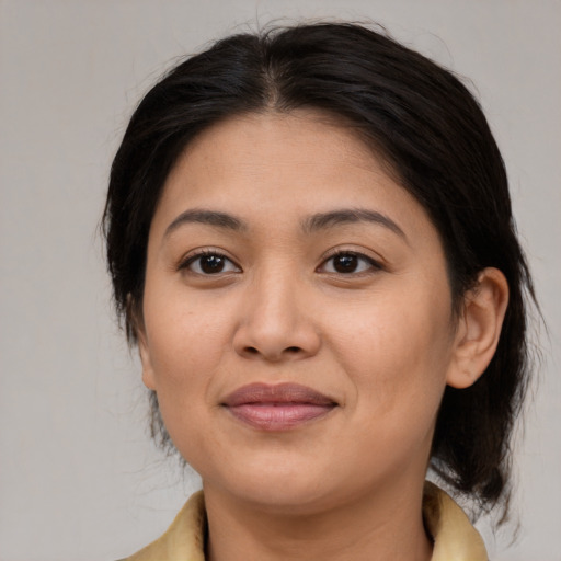 Joyful latino adult female with medium  brown hair and brown eyes