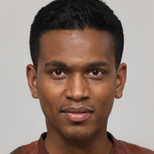 Joyful black young-adult male with short  black hair and brown eyes